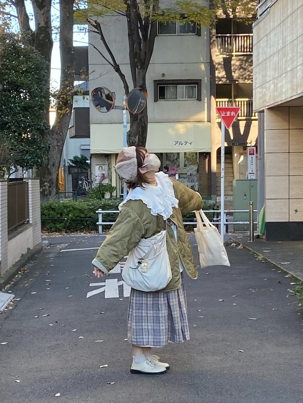 グリーン系のノーカラージャケット、ベージュ系のショルダーバッグ、ベージュ系のキャップを着用したレディースの秋コーディネートの2枚目の写真