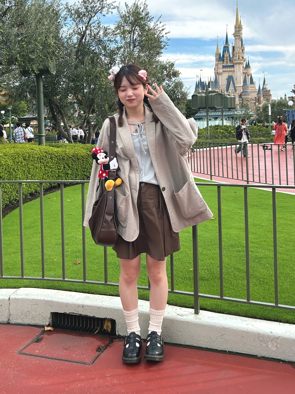 グレー系のノーカラージャケット、ブラウン系のショルダーバッグ、ブラウン系のスカートを着用したレディースの秋コーディネートの2枚目の写真