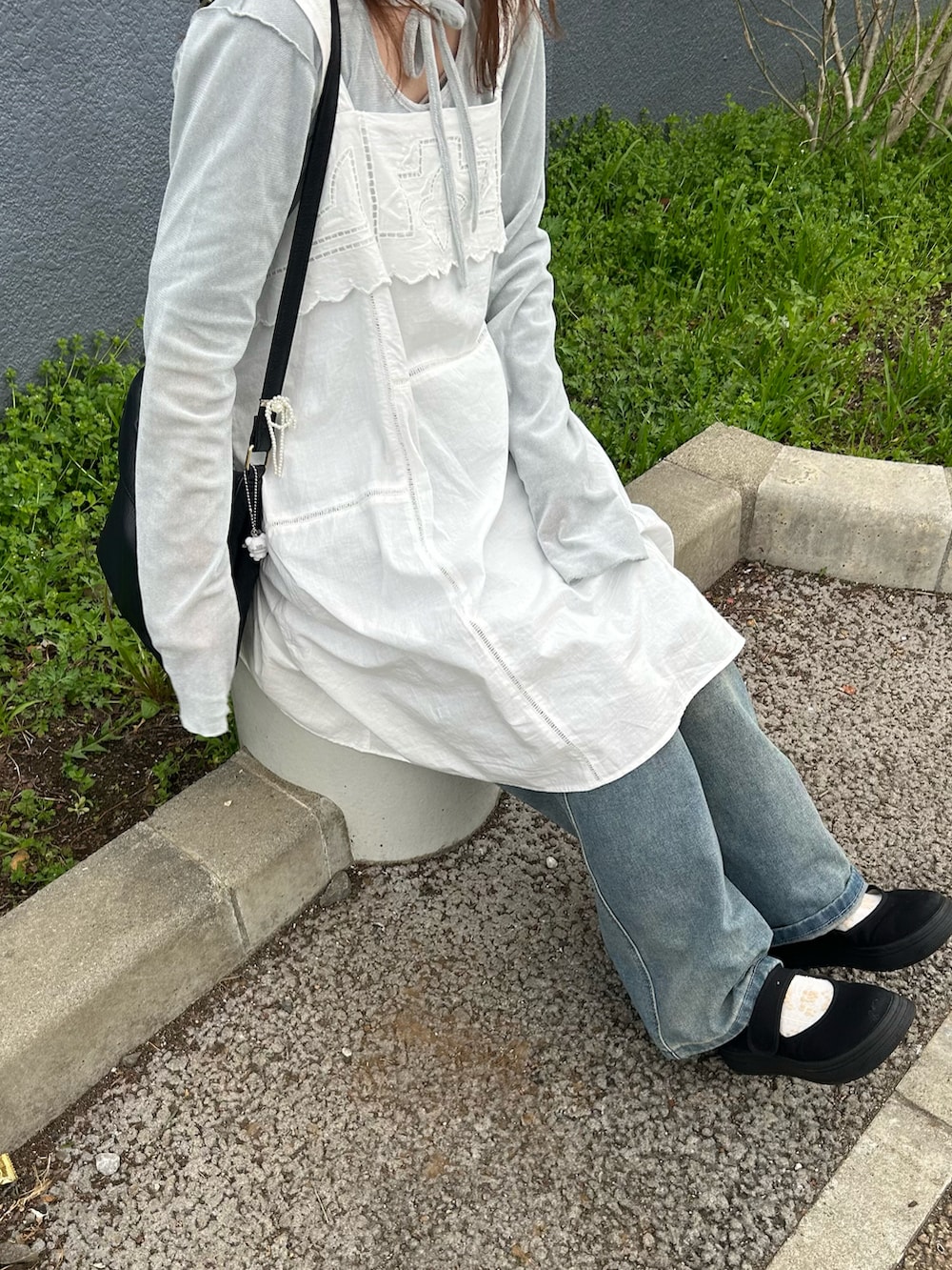 ブルー系のTシャツ/カットソー、ブラック系のハンドバッグ、ホワイト系のトップスを着用したレディースの春コーディネートの2枚目の写真