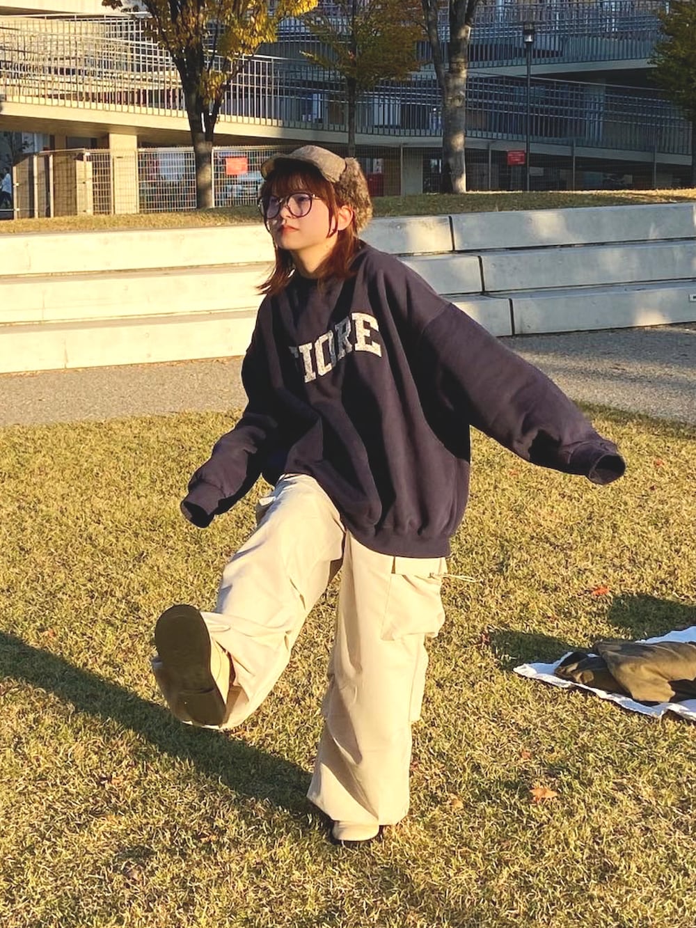 ブルー系のスウェット、ベージュ系のカーゴパンツ、ベージュ系のキャップを着用したレディースの秋コーディネートの2枚目の写真