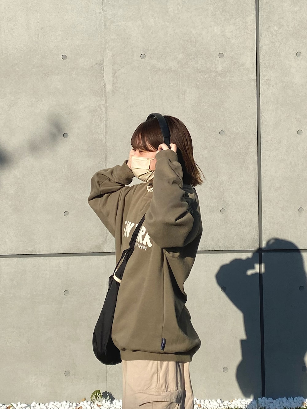 ベージュ系のカーゴパンツ、ブラック系のショルダーバッグ、ブラック系のブーツを着用したレディースの秋コーディネートの2枚目の写真