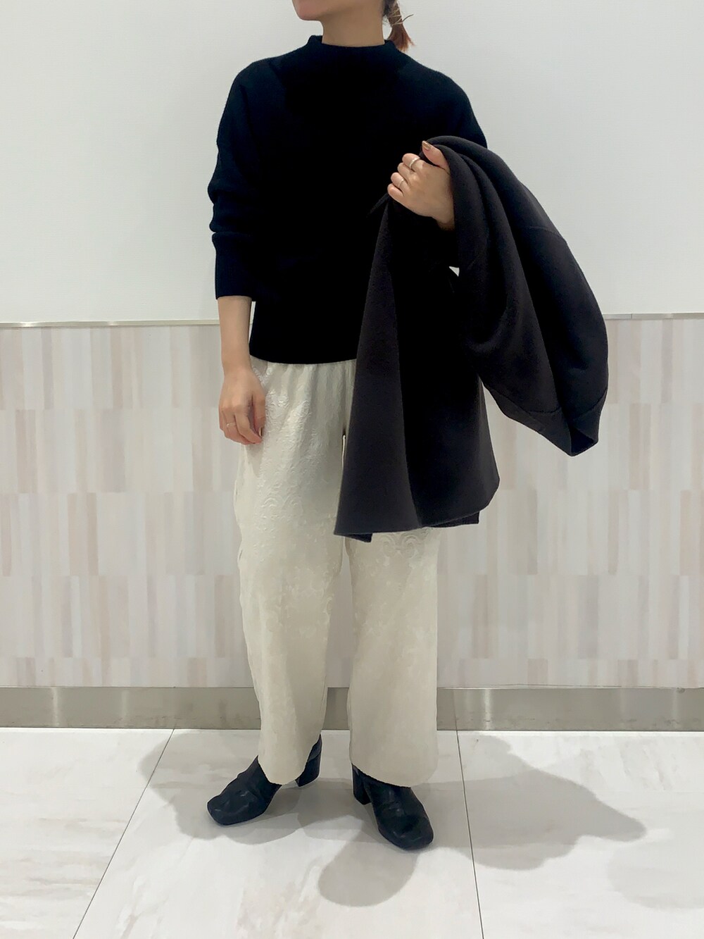 ブラック系のニット/セーター、ブラウン系のジャケット/アウター、ホワイト系のその他パンツを着用したレディースの冬コーディネートの3枚目の写真