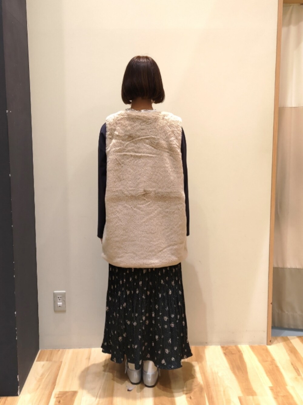 ベージュ系のベスト、グレー系のTシャツ/カットソー、ブラック系のスカートを着用したレディースの秋コーディネートの4枚目の写真