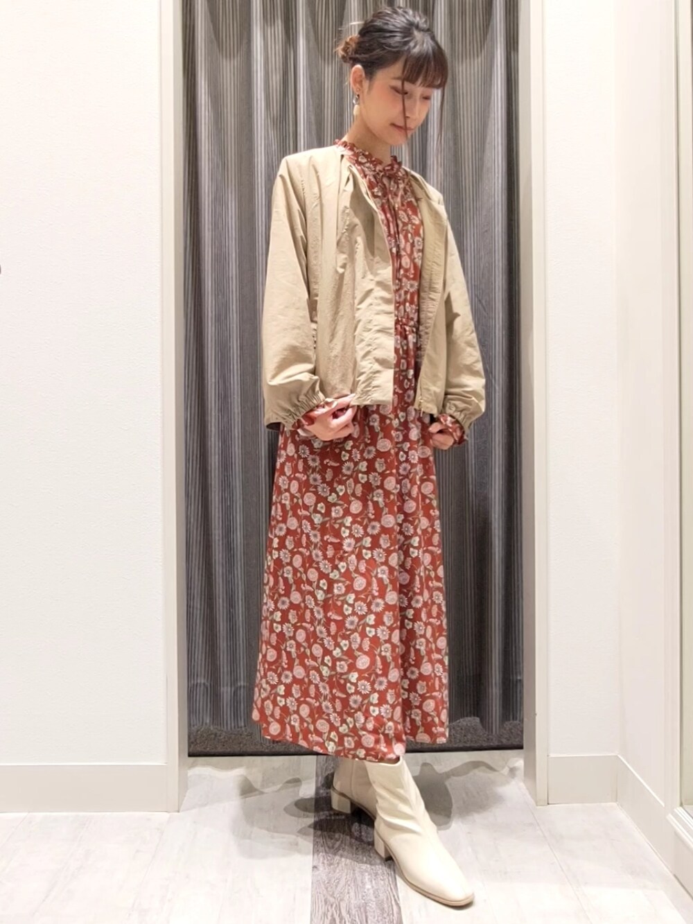 ベージュ系のブルゾン、レッド系のワンピース、ホワイト系のブーツを着用したレディースの秋コーディネートの4枚目の写真