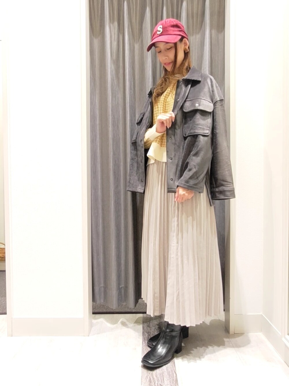 グレー系のスカート、ブラック系のブーツ、グレー系のノーカラージャケットを着用したレディースの秋コーディネートの3枚目の写真