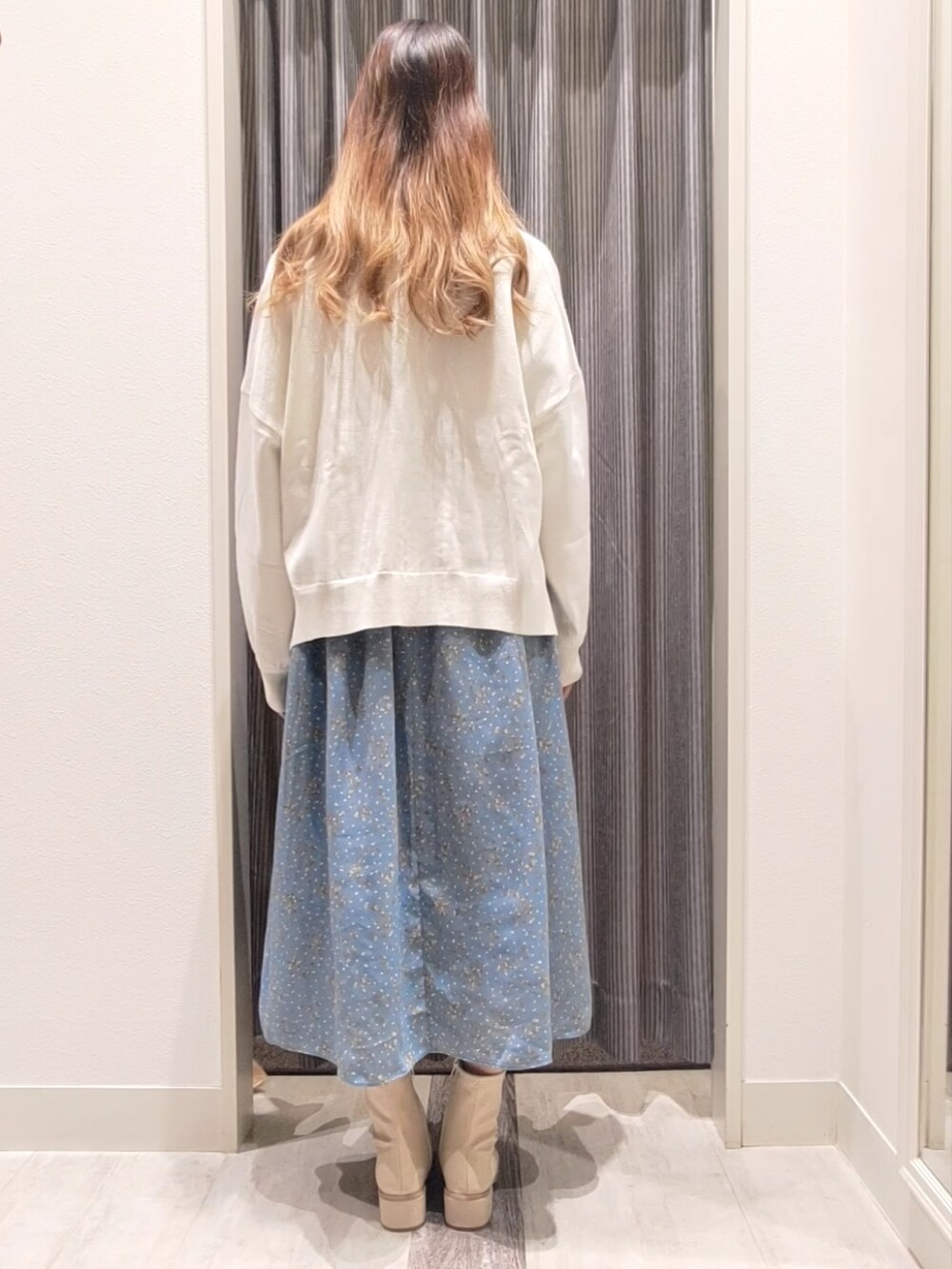 ホワイト系のカーディガン/ボレロ、ホワイト系のブーツ、グリーン系のワンピースを着用したレディースの秋コーディネートの3枚目の写真