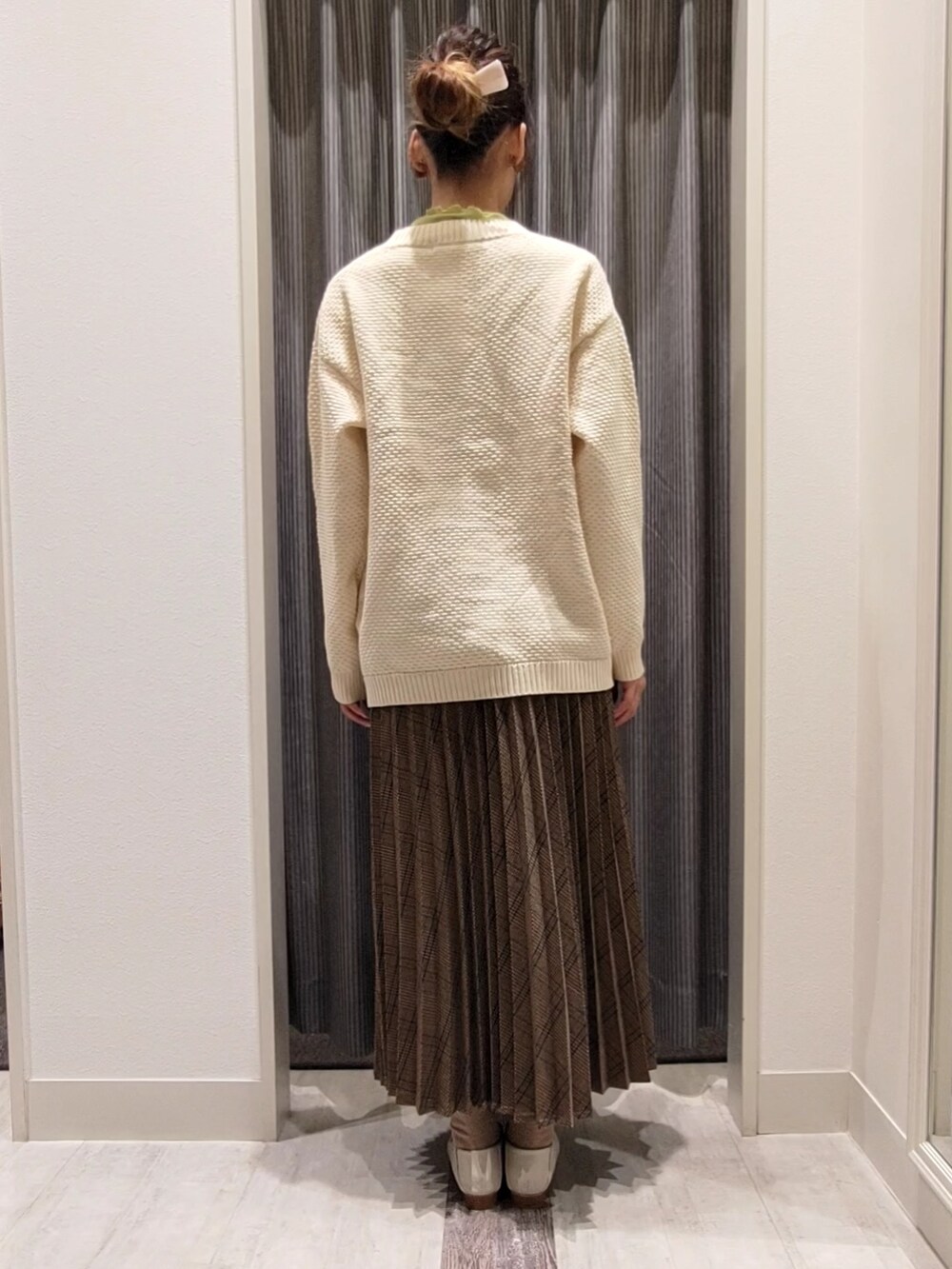 ホワイト系のカーディガン/ボレロ、グリーン系のニット/セーター、ブラウン系のスカートを着用したレディースの秋コーディネートの3枚目の写真