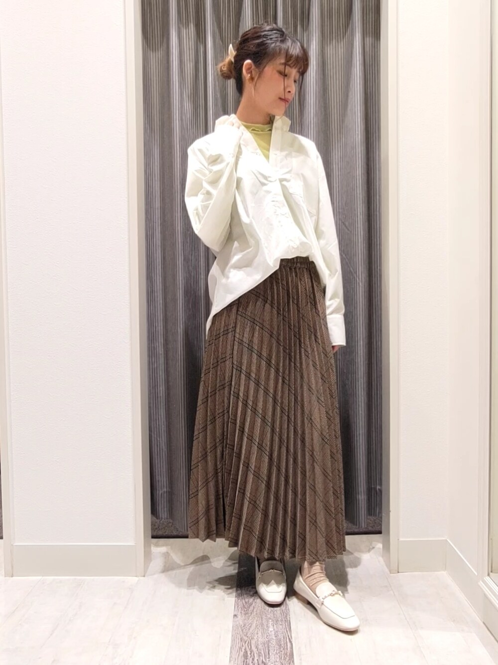ホワイト系のドレスシューズ、ブラウン系のスカート、ホワイト系のシャツ/ブラウスを着用したレディースの秋コーディネートの2枚目の写真