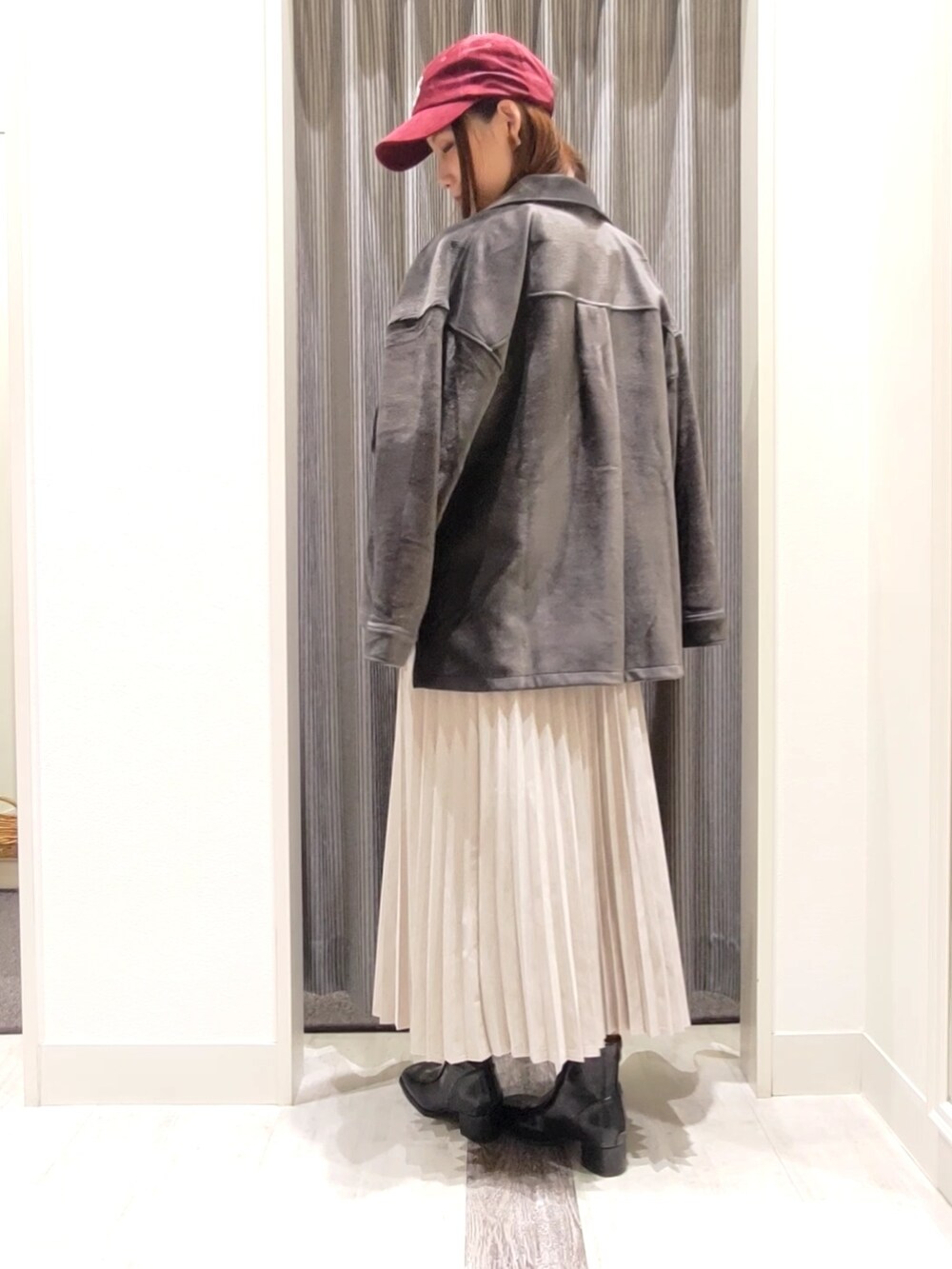 グレー系のスカート、ブラック系のブーツ、グレー系のノーカラージャケットを着用したレディースの秋コーディネートの2枚目の写真