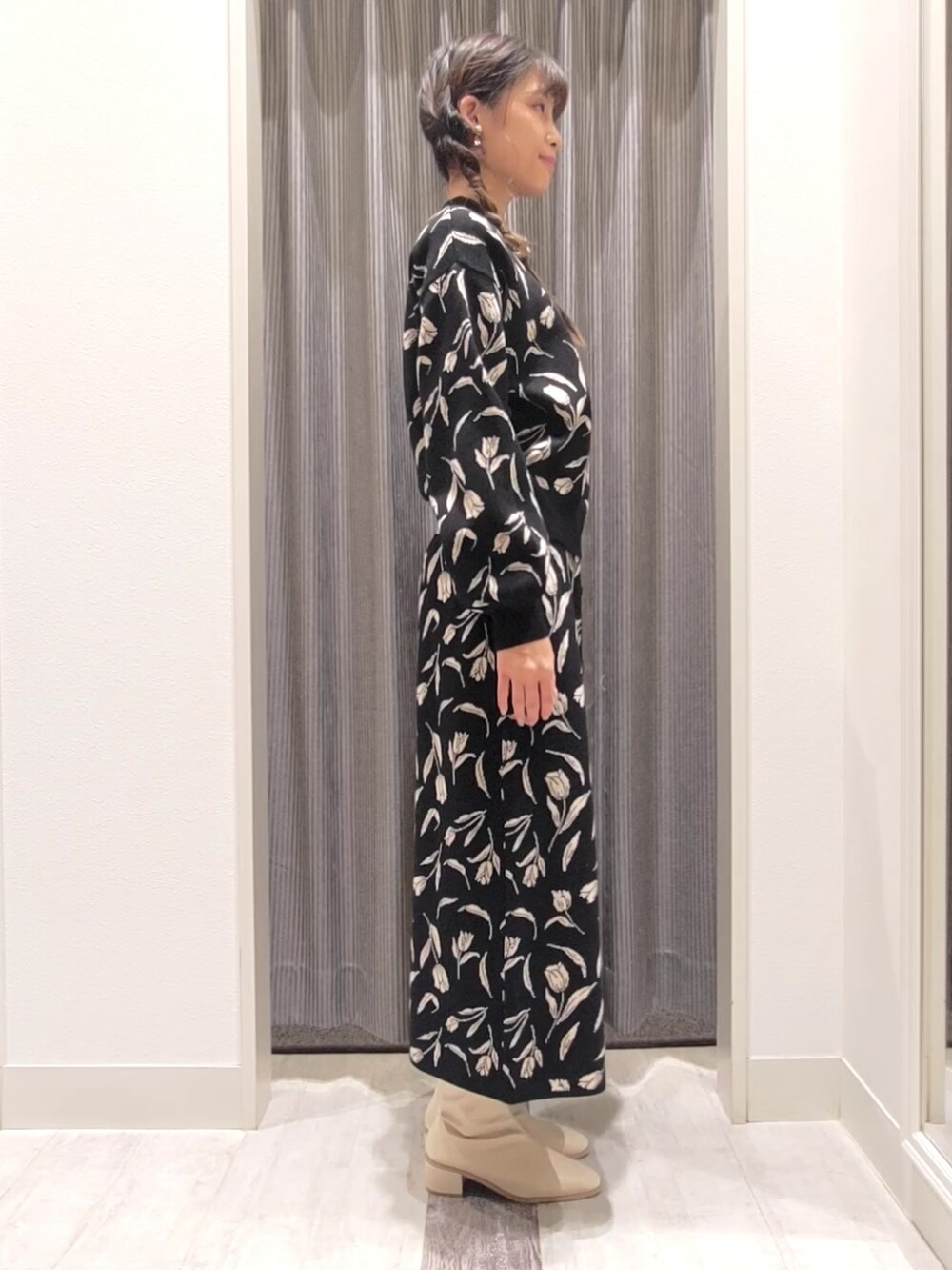 ホワイト系のブーツ、ブラック系のスカート、ブラック系のニット/セーターを着用したレディースの冬コーディネートの2枚目の写真