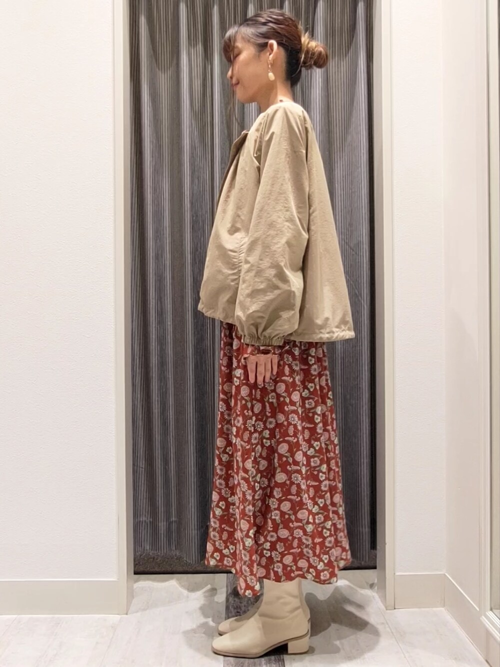 ベージュ系のブルゾン、レッド系のワンピース、ホワイト系のブーツを着用したレディースの秋コーディネートの3枚目の写真