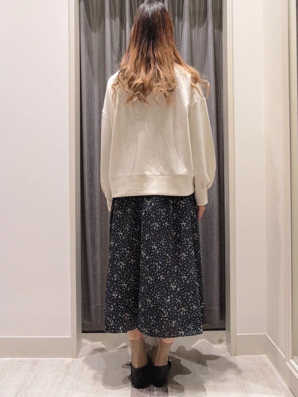 ブルー系のスカート、ブラック系のドレスシューズ、ホワイト系のTシャツ/カットソーを着用したレディースの秋コーディネートの3枚目の写真