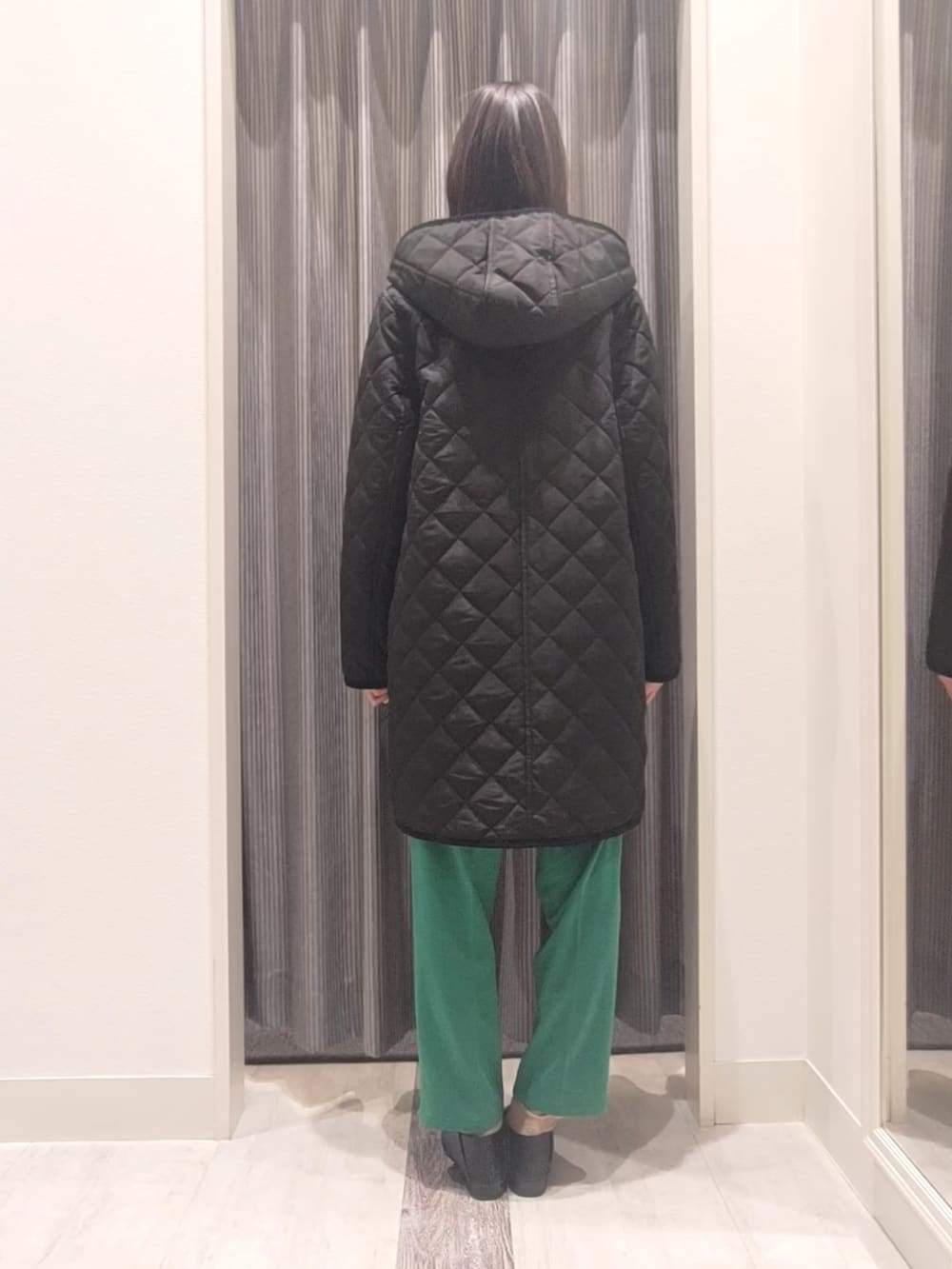 ホワイト系のニット/セーター、ブラック系のその他アウター、グリーン系のその他パンツを着用したレディースの冬コーディネートの3枚目の写真