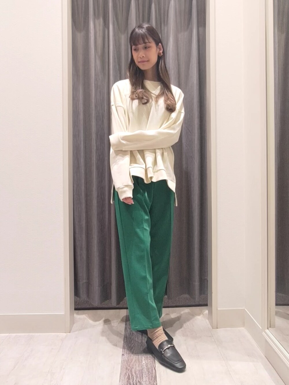 ホワイト系のニット/セーター、ブラック系のその他アウター、グリーン系のその他パンツを着用したレディースの冬コーディネートの4枚目の写真