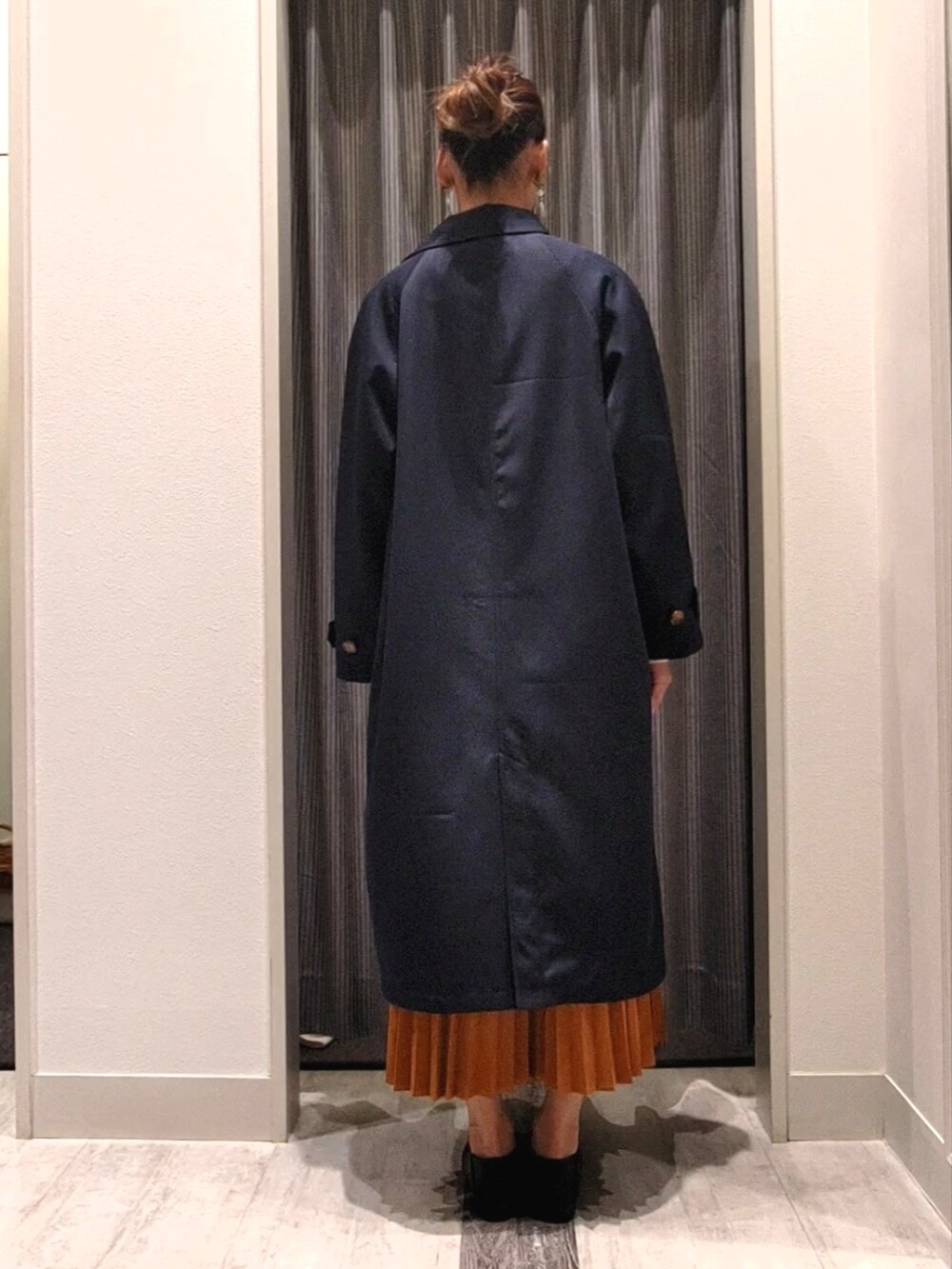 ブラック系のドレスシューズ、ホワイト系のニット/セーター、ブルー系のステンカラーコートを着用したレディースの秋コーディネートの3枚目の写真