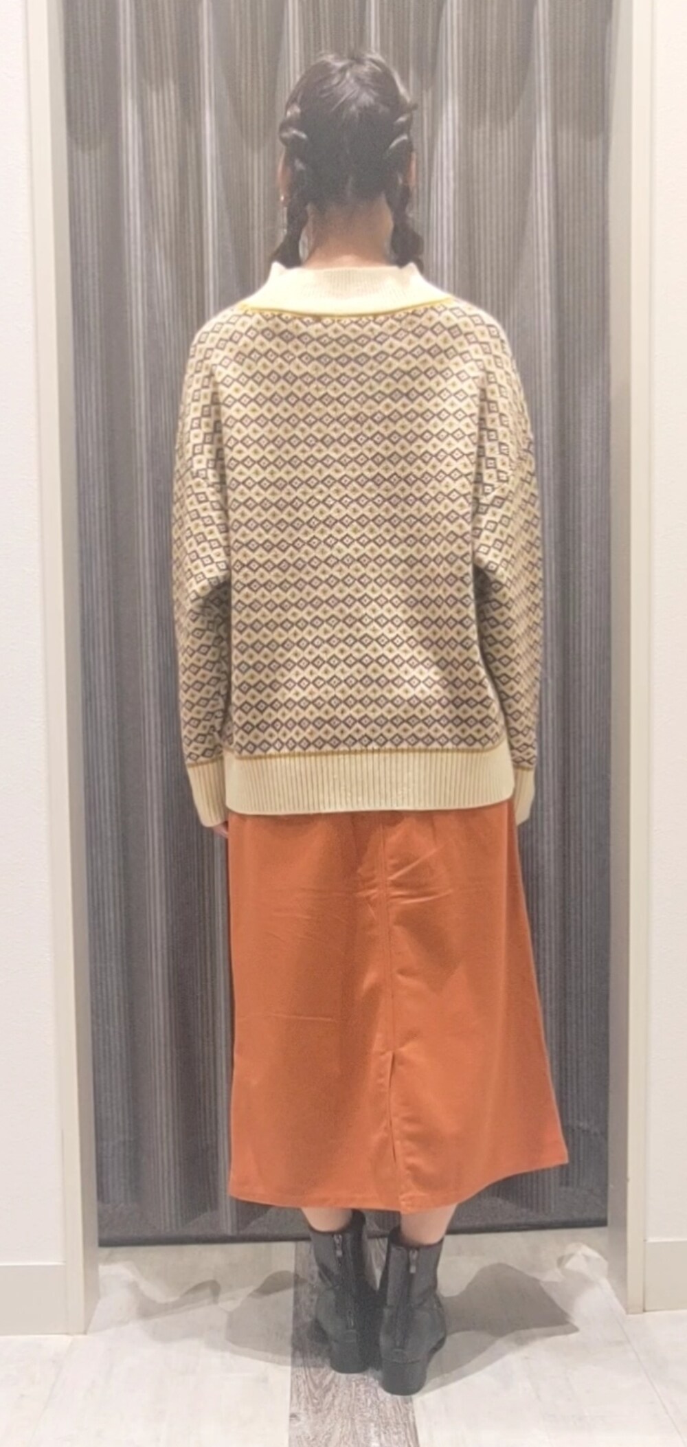 ホワイト系のハンドバッグ、ブラック系のブーツ、イエロー系のニット/セーターを着用したレディースの秋コーディネートの4枚目の写真