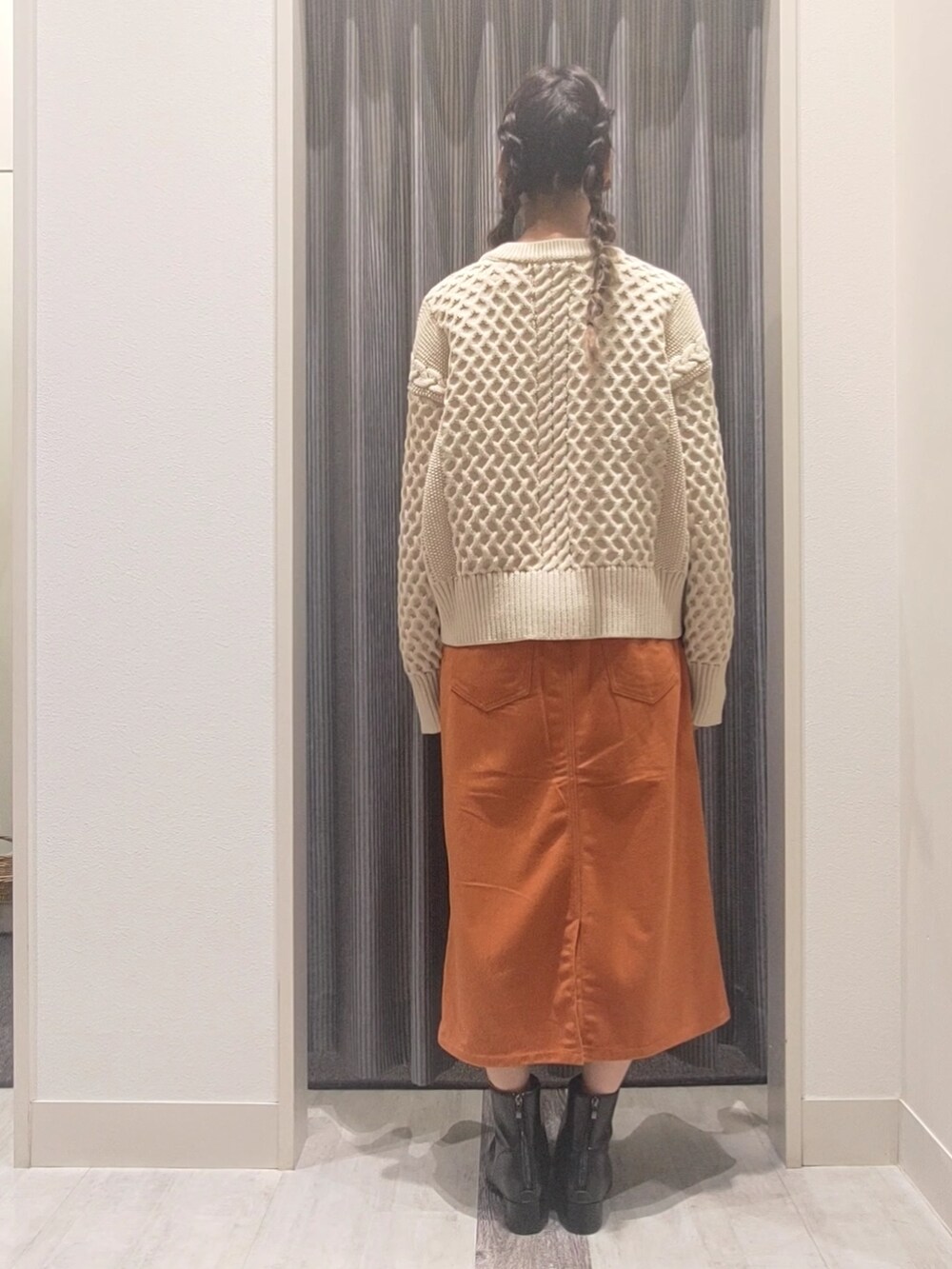 ホワイト系のカーディガン/ボレロ、オレンジ系のスカート、ブラック系のブーツを着用したレディースの秋コーディネートの4枚目の写真