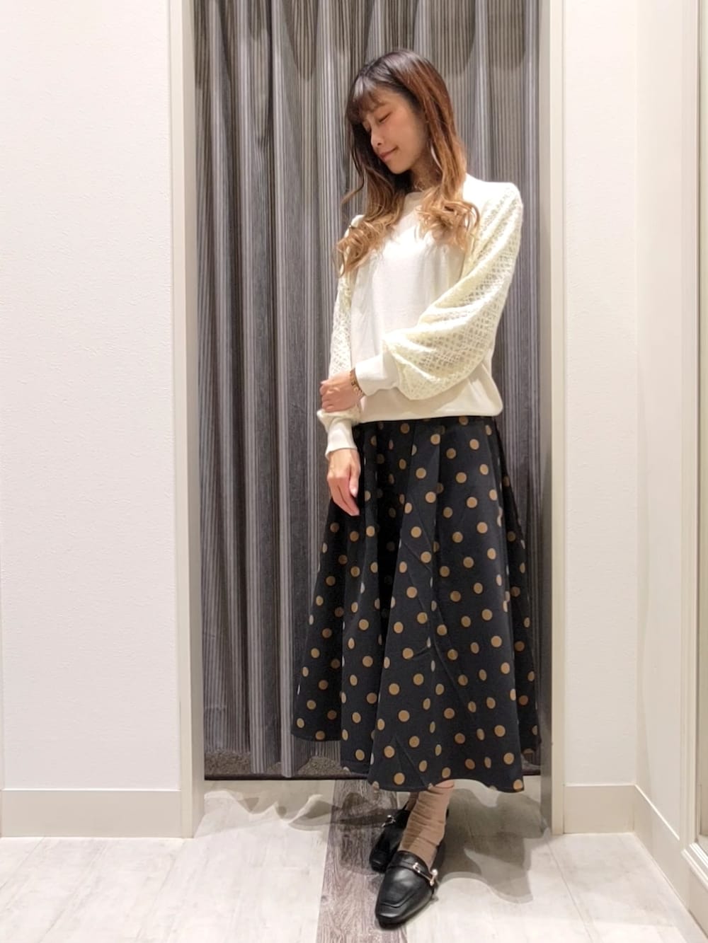 ブラック系のスカート、ブラック系のドレスシューズを着用したレディースの秋コーディネートの4枚目の写真