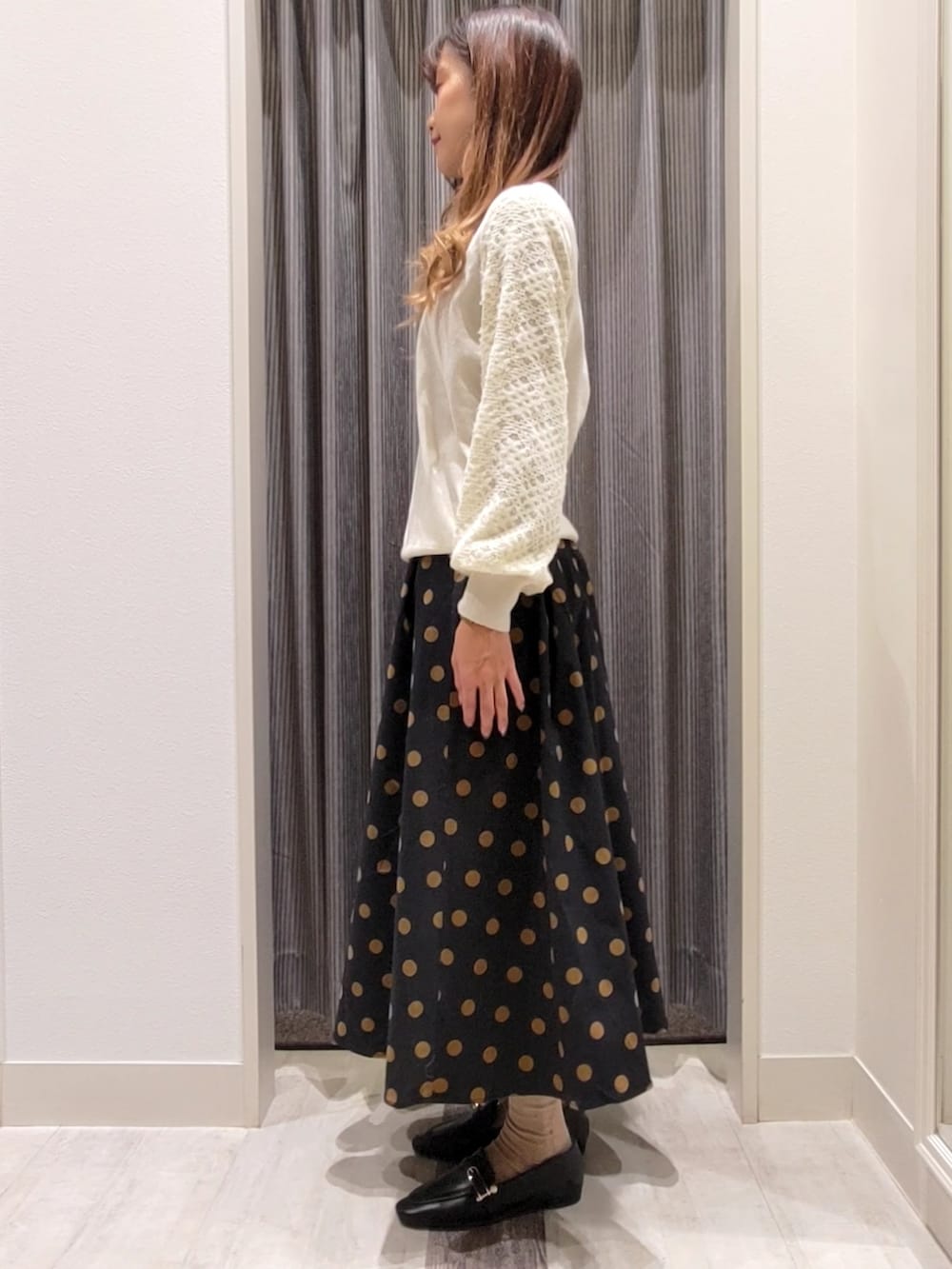 ブラック系のスカート、ブラック系のドレスシューズを着用したレディースの秋コーディネートの2枚目の写真