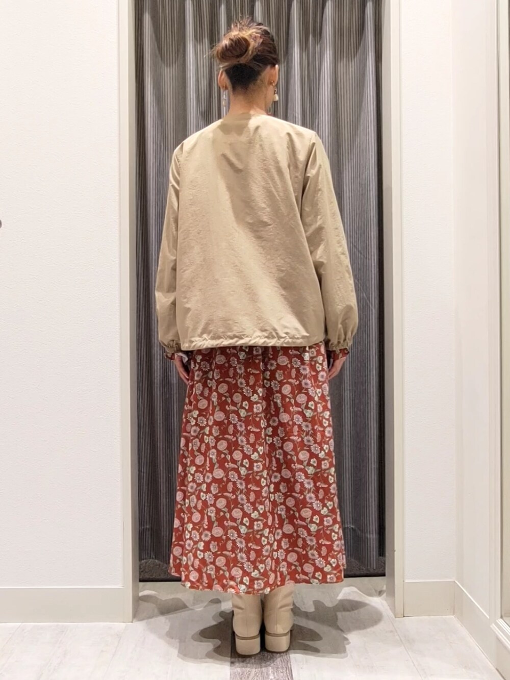 ベージュ系のブルゾン、レッド系のワンピース、ホワイト系のブーツを着用したレディースの秋コーディネートの2枚目の写真