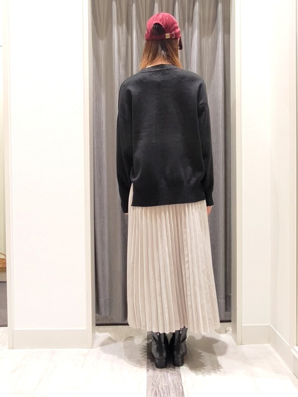 ブラック系のニット/セーター、グレー系のスカート、ブラック系のブーツを着用したレディースの秋コーディネートの3枚目の写真