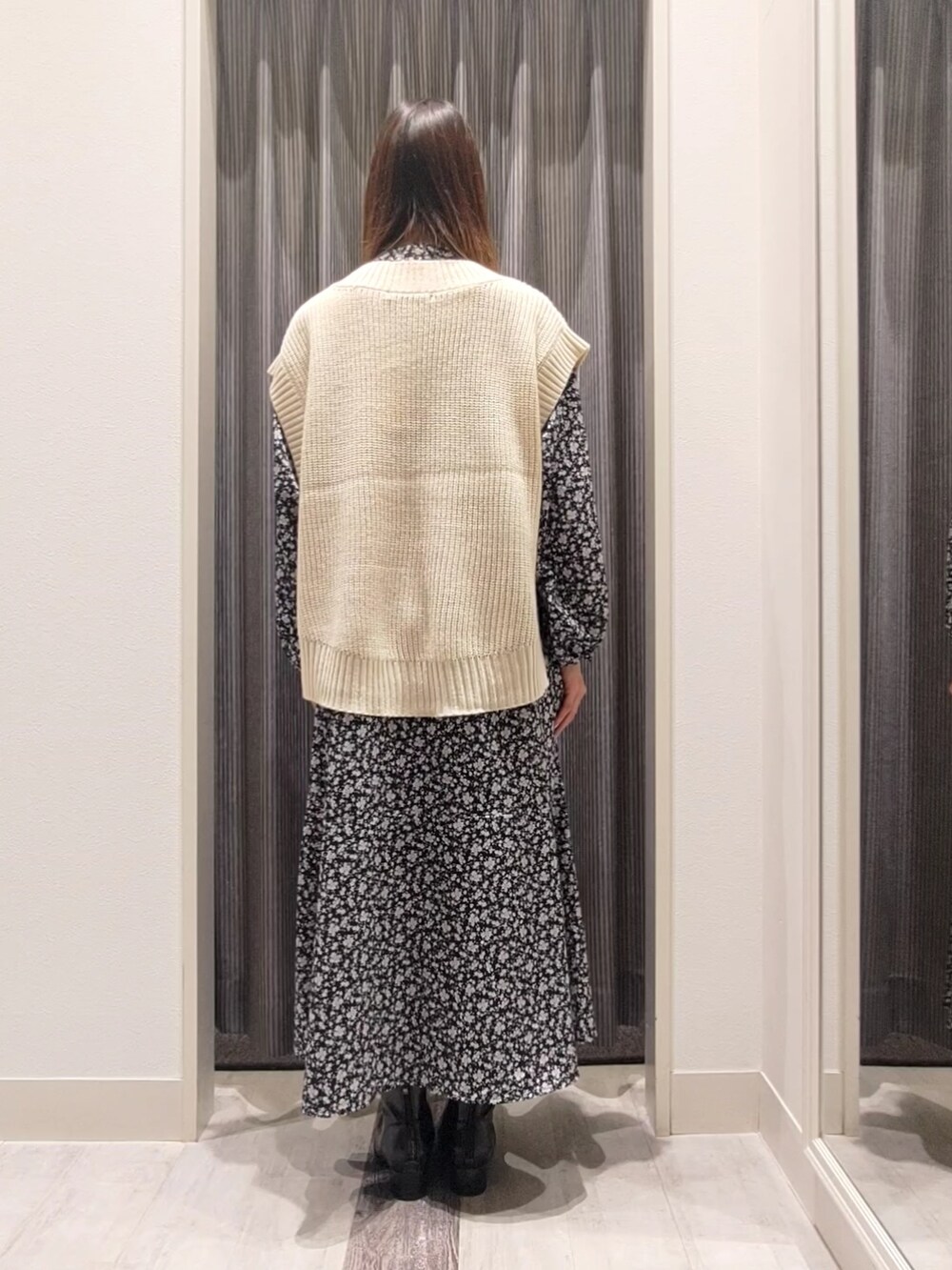 ブラック系のブーツ、ブラック系のワンピース、ホワイト系のベストを着用したレディースの秋コーディネートの3枚目の写真