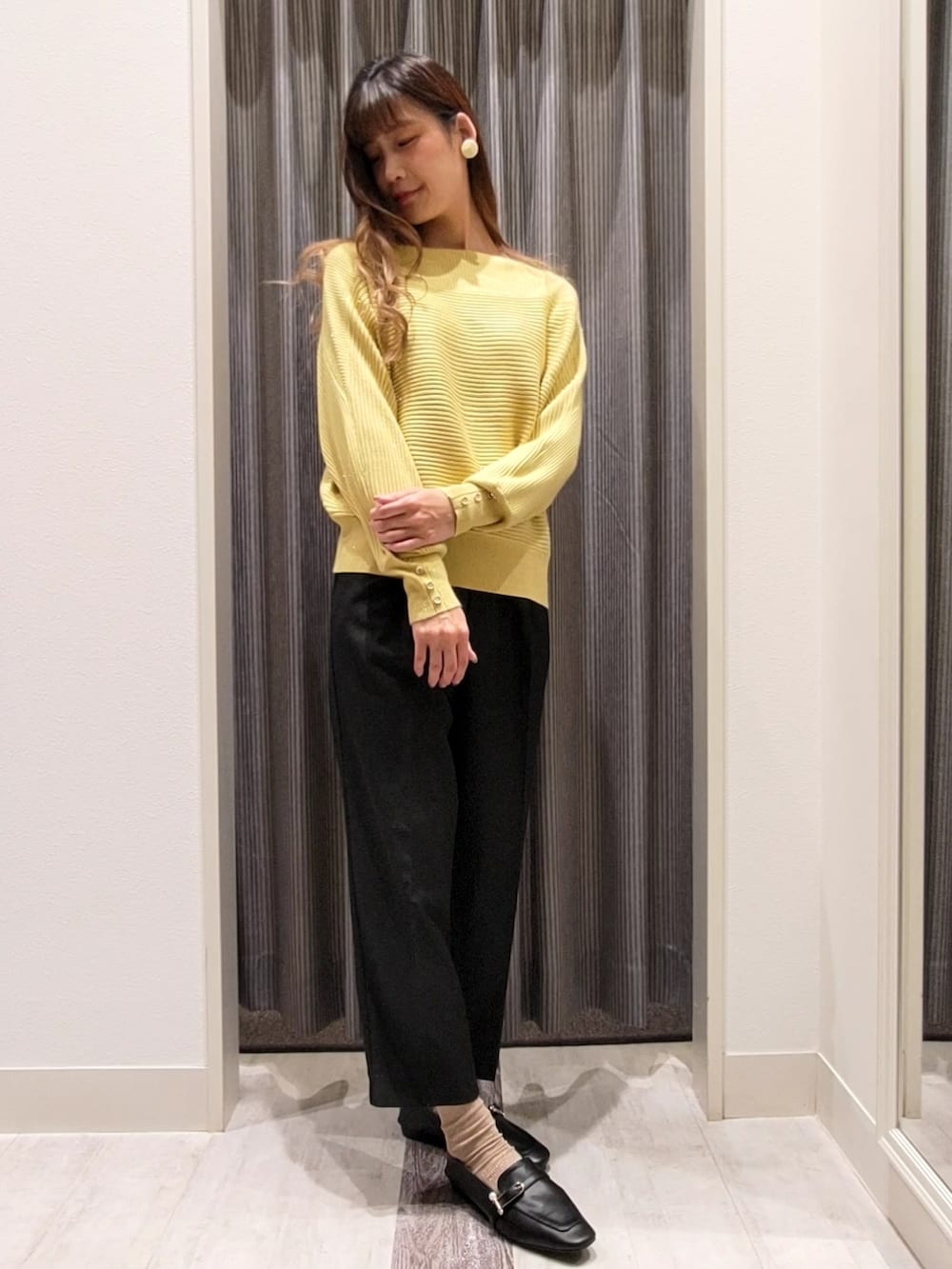 ベージュ系のその他アウター、イエロー系のニット/セーター、ブラック系のドレスシューズを着用したレディースの秋コーディネートの5枚目の写真
