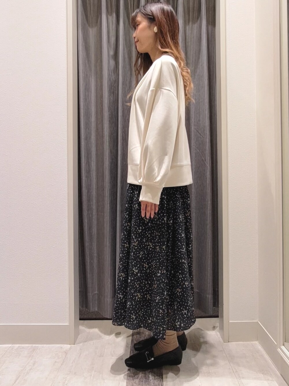 ブルー系のスカート、ブラック系のドレスシューズ、ホワイト系のTシャツ/カットソーを着用したレディースの秋コーディネートの2枚目の写真