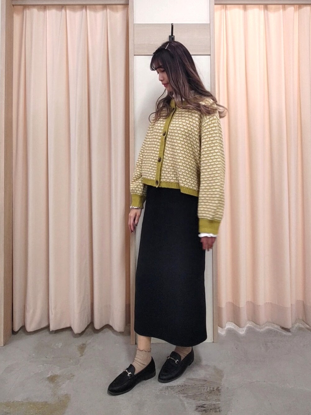ブラック系のスカート、グリーン系のカーディガン/ボレロを着用したレディースの春コーディネートの3枚目の写真