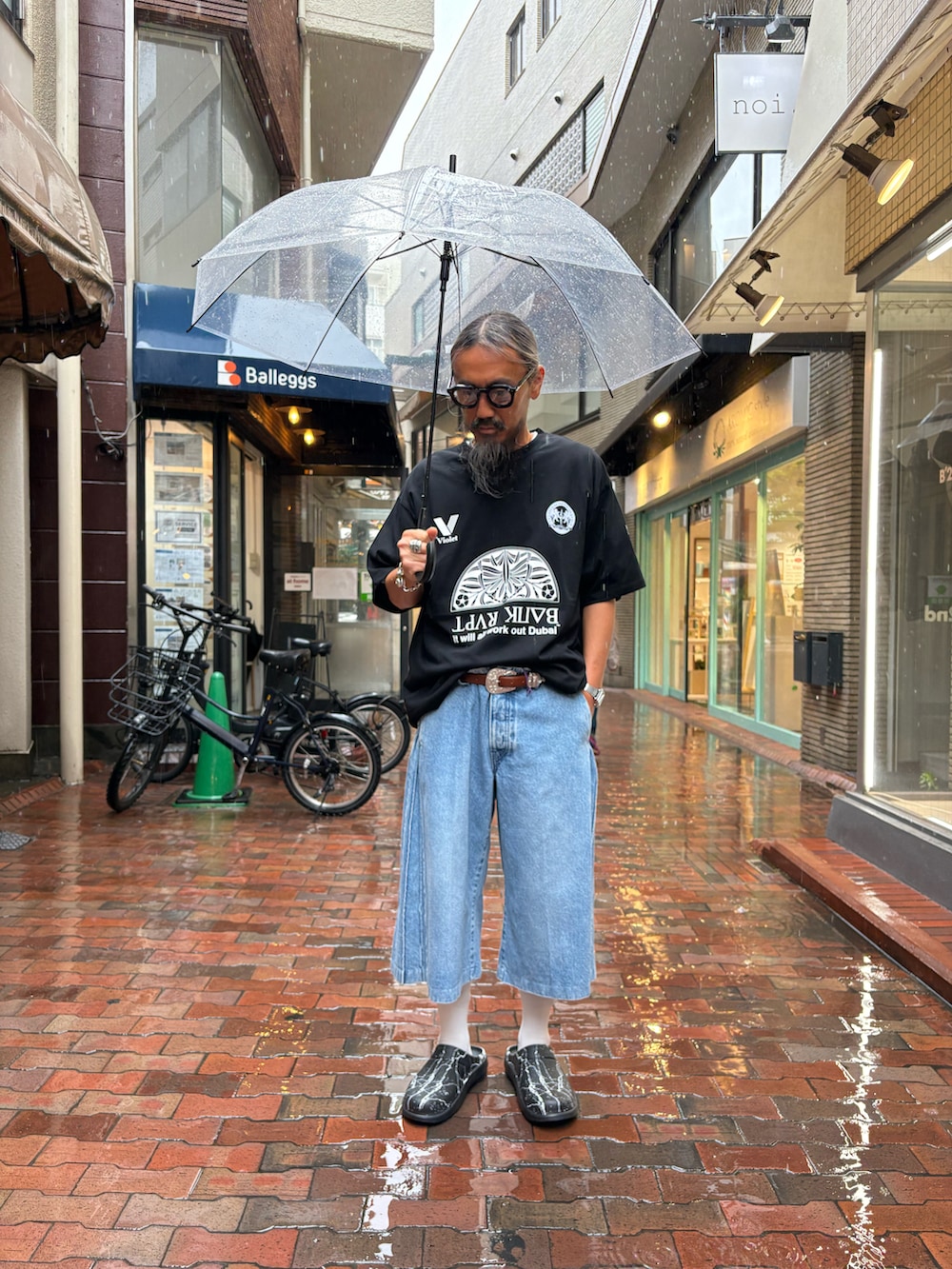 ブラック系のサンダル、ブルー系のデニムパンツ、ブラック系のTシャツ/カットソーを着用したメンズの春コーディネートの2枚目の写真