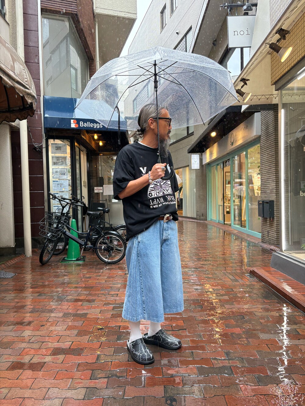 ブラック系のサンダル、ブルー系のデニムパンツ、ブラック系のTシャツ/カットソーを着用したメンズの春コーディネートの3枚目の写真