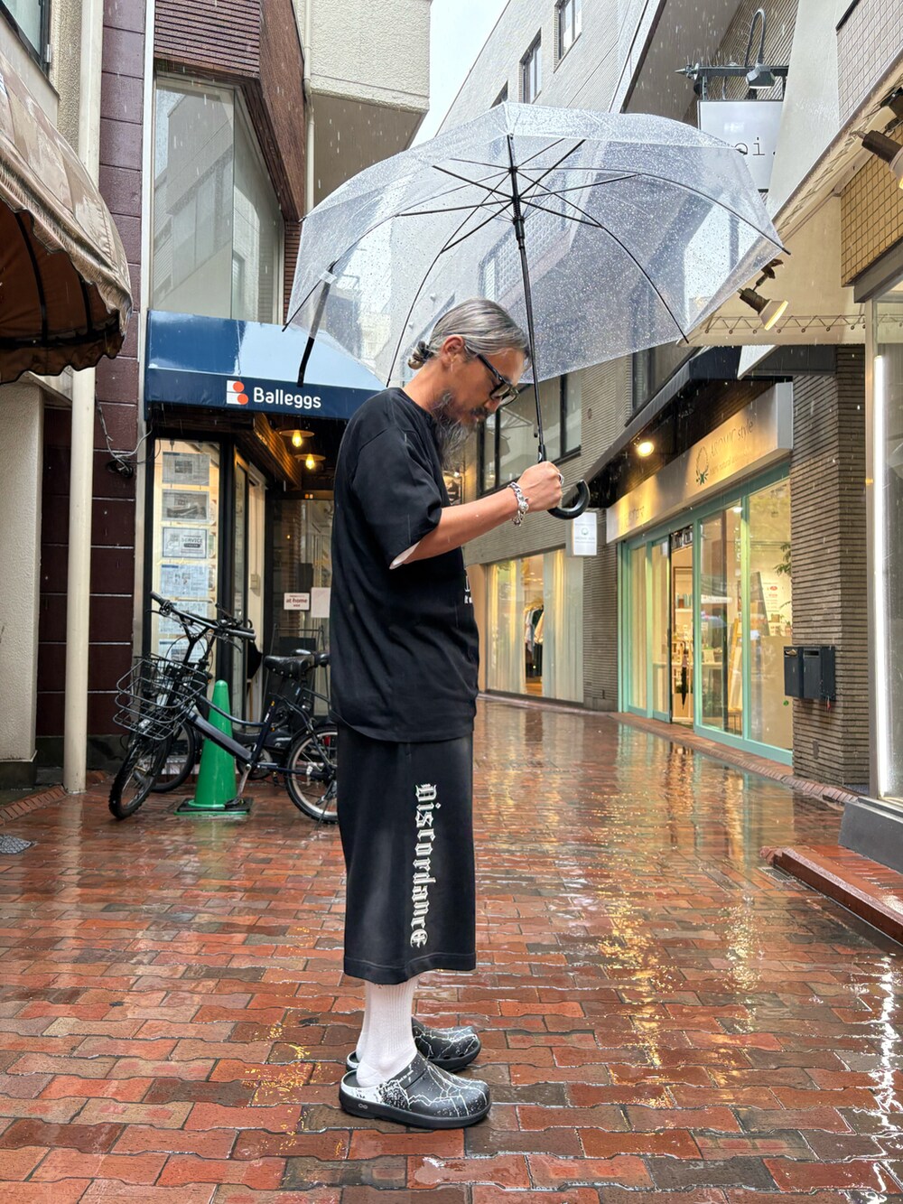 ブラック系のサンダル、ブラック系のスウェットパンツ、ブラック系のTシャツ/カットソーを着用したメンズの春コーディネートの3枚目の写真
