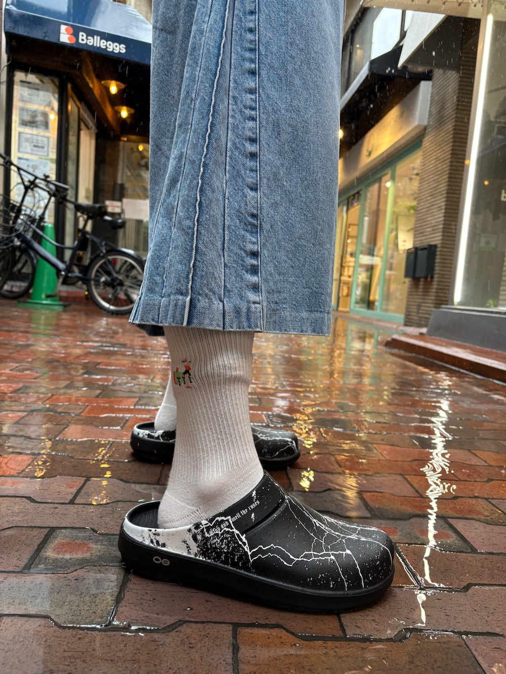 ブラック系のサンダル、ブルー系のデニムパンツ、ブラック系のTシャツ/カットソーを着用したメンズの春コーディネートの5枚目の写真