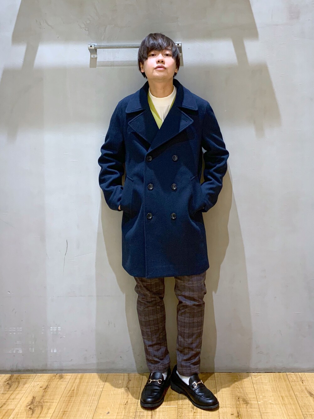 イエロー系のカーディガン/ボレロ、グレー系のその他パンツ、ブルー系のトレンチコートを着用したメンズの冬コーディネートの2枚目の写真
