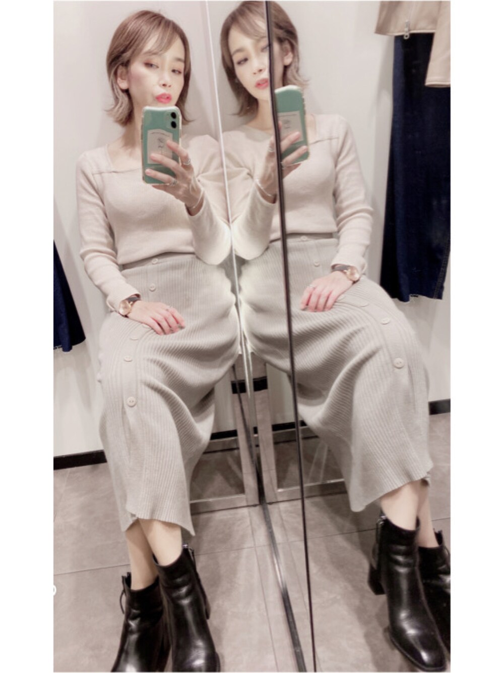 ベージュ系のスカート、ベージュ系のトップス、ブラック系のブーツを着用したレディースの秋コーディネートの2枚目の写真