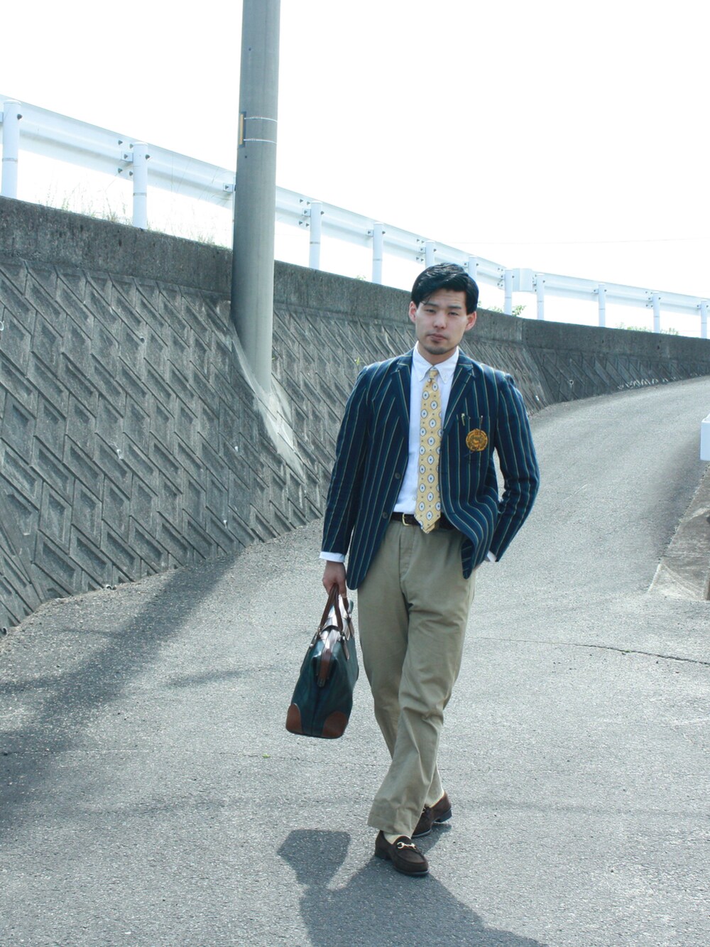 ブラウン系のローファー、ベージュ系のチノパンツ、グリーン系のテーラードジャケットを着用したメンズの夏コーディネートの2枚目の写真