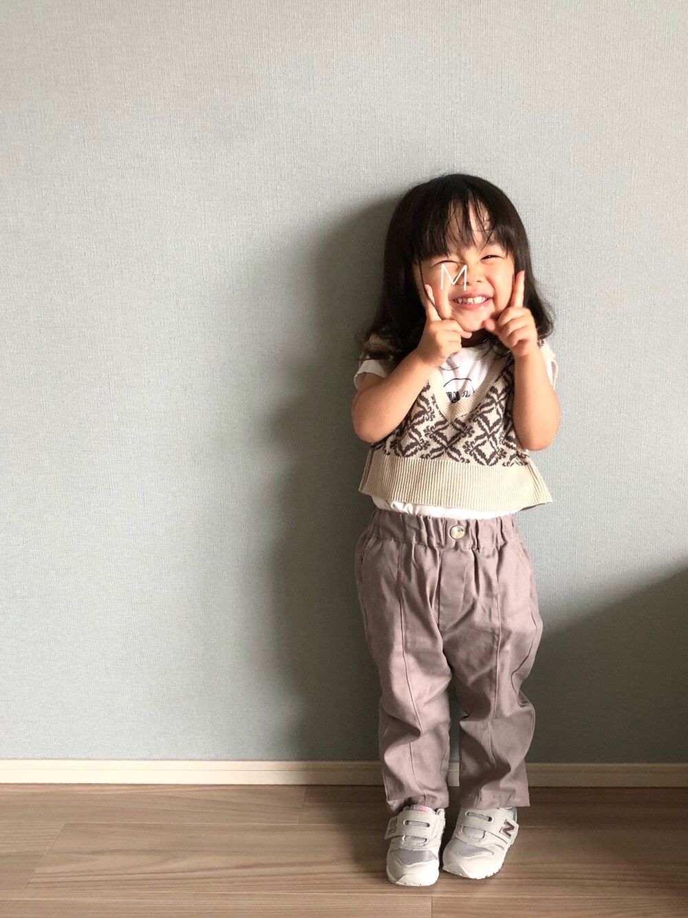 ベージュ系のベスト、ホワイト系のTシャツ/カットソー、ピンク系のパンツを着用したキッズの秋コーディネートの2枚目の写真