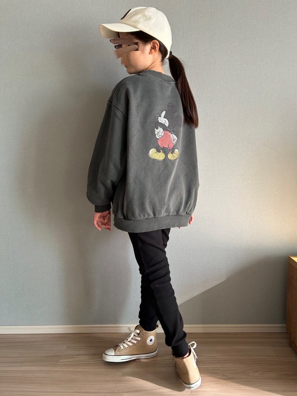 グレー系のスウェット、ベージュ系のスニーカー、ブラック系のバッグを着用したキッズの秋コーディネートの2枚目の写真