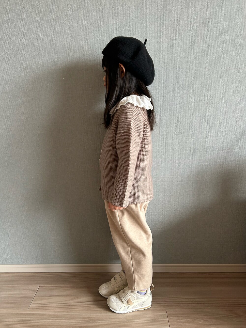 ホワイト系のTシャツ/カットソー、ブラウン系のカーディガン/ボレロ、ベージュ系のパンツを着用したキッズの冬コーディネートの2枚目の写真