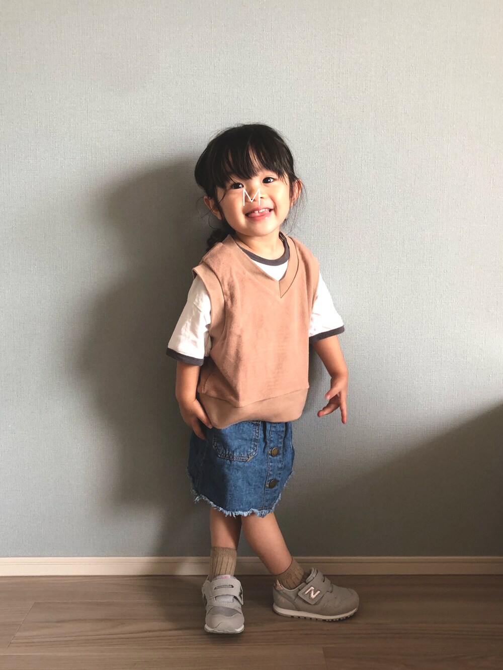 ブラウン系のベスト、ホワイト系のTシャツ/カットソー、ブルー系のデニムスカートを着用したキッズの秋コーディネートの2枚目の写真