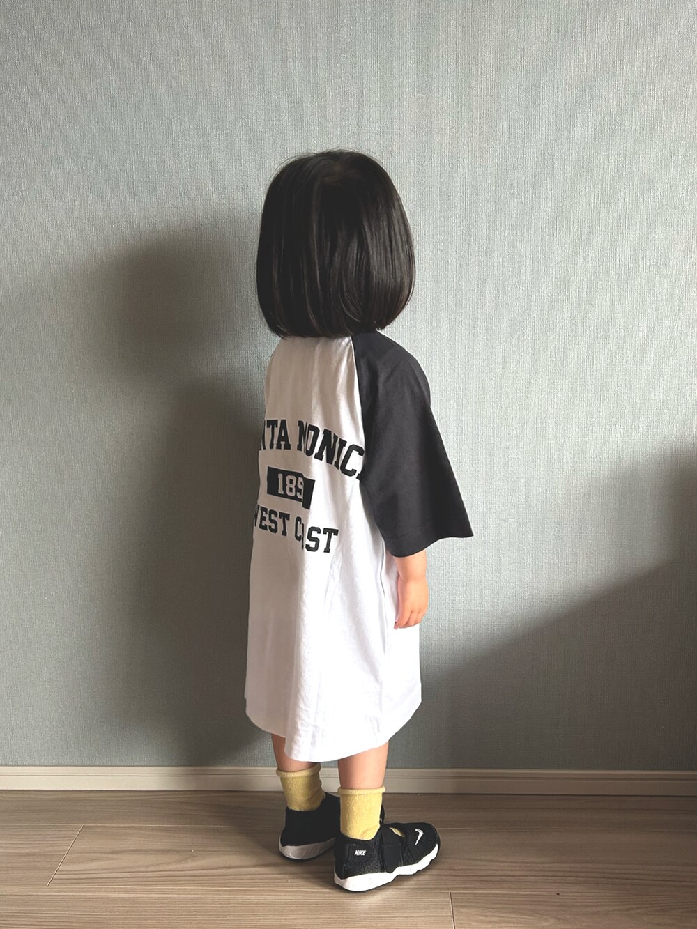 ホワイト系のワンピース、ブラック系のスニーカー、その他のソックス/靴下を着用したキッズの春コーディネートの3枚目の写真