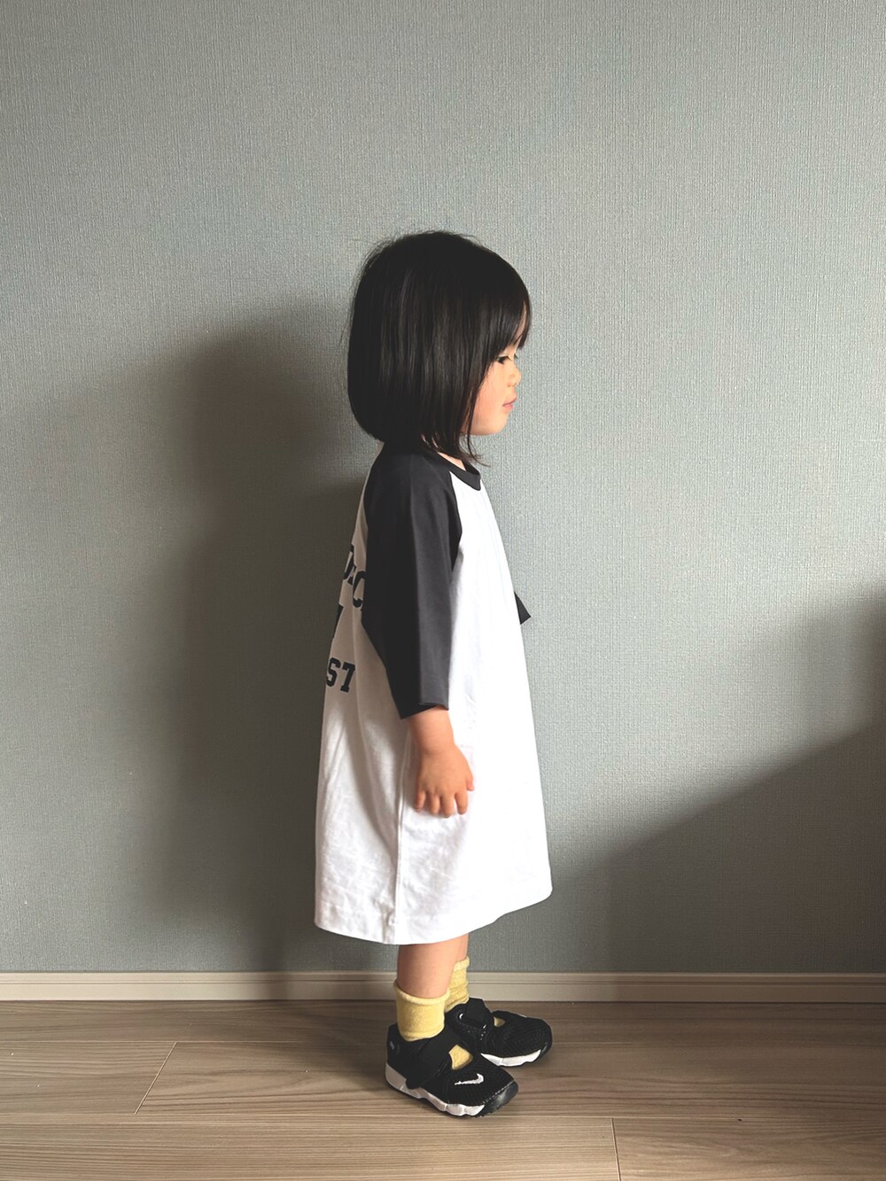 ホワイト系のワンピース、ブラック系のスニーカー、その他のソックス/靴下を着用したキッズの春コーディネートの2枚目の写真