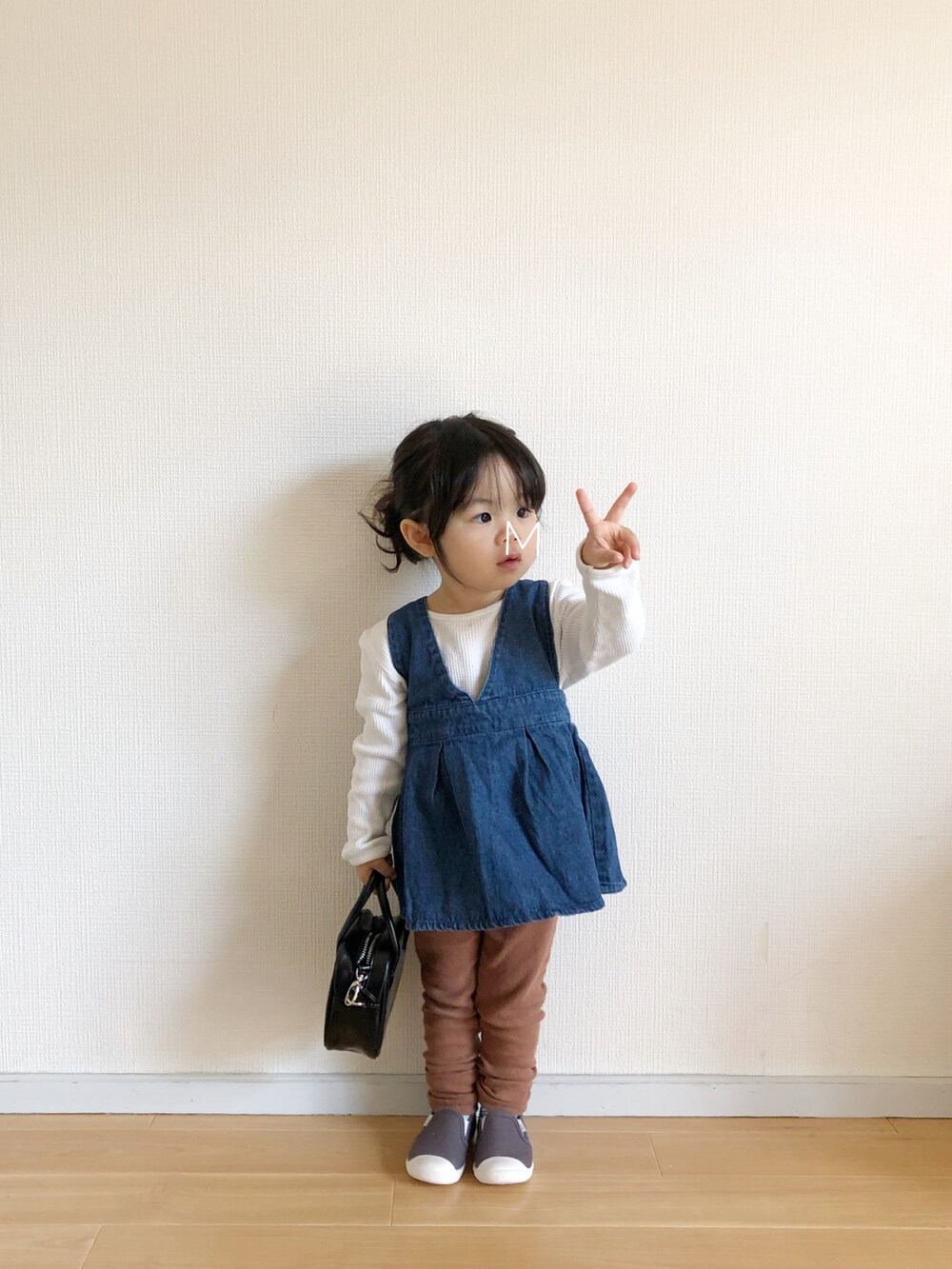 ブルー系のオールインワン・サロペット、ベージュ系のTシャツ/カットソー、グレー系のスリッポンを着用したキッズの春コーディネートの2枚目の写真