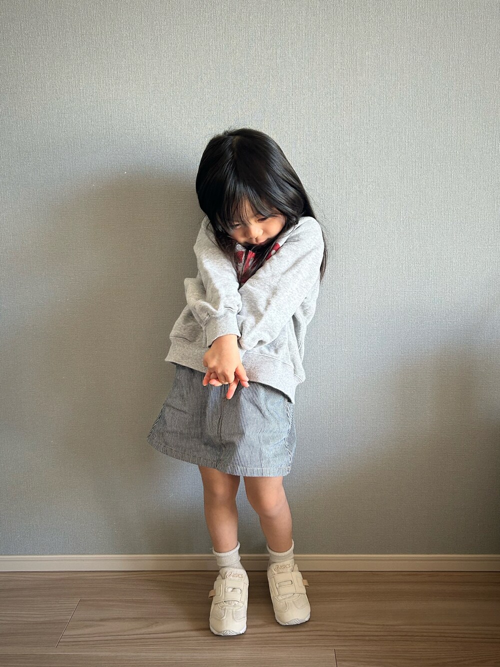グレー系のスウェット、その他のスカート、ホワイト系のスニーカーを着用したキッズの春コーディネートの2枚目の写真