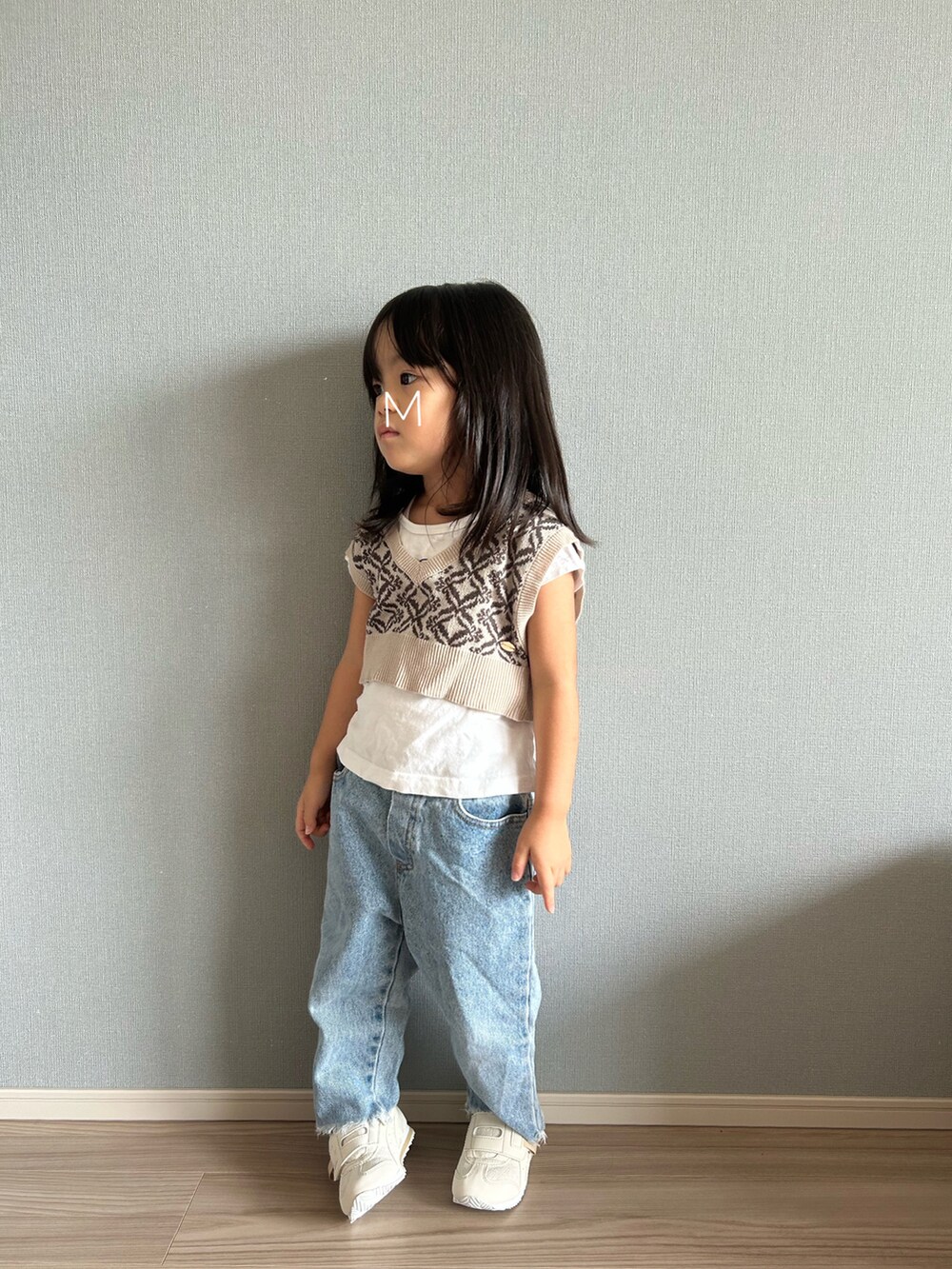 ベージュ系のベスト、ホワイト系のTシャツ/カットソー、ブルー系のデニムパンツを着用したキッズの秋コーディネートの2枚目の写真
