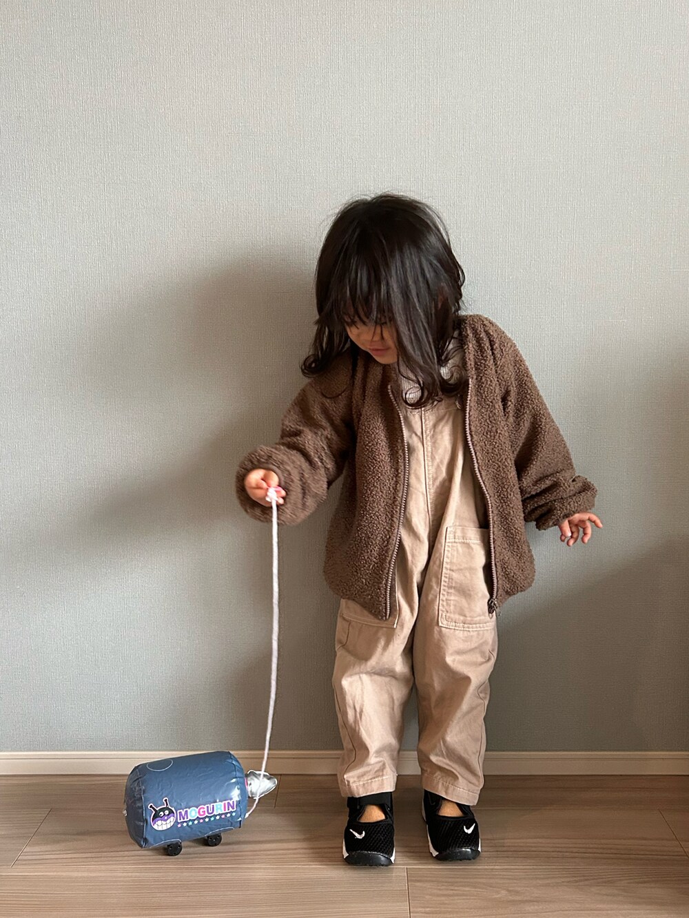 ブラウン系のブルゾン、ベージュ系のTシャツ/カットソー、ベージュ系のサロペット/オーバーオールを着用したキッズの秋コーディネートの3枚目の写真