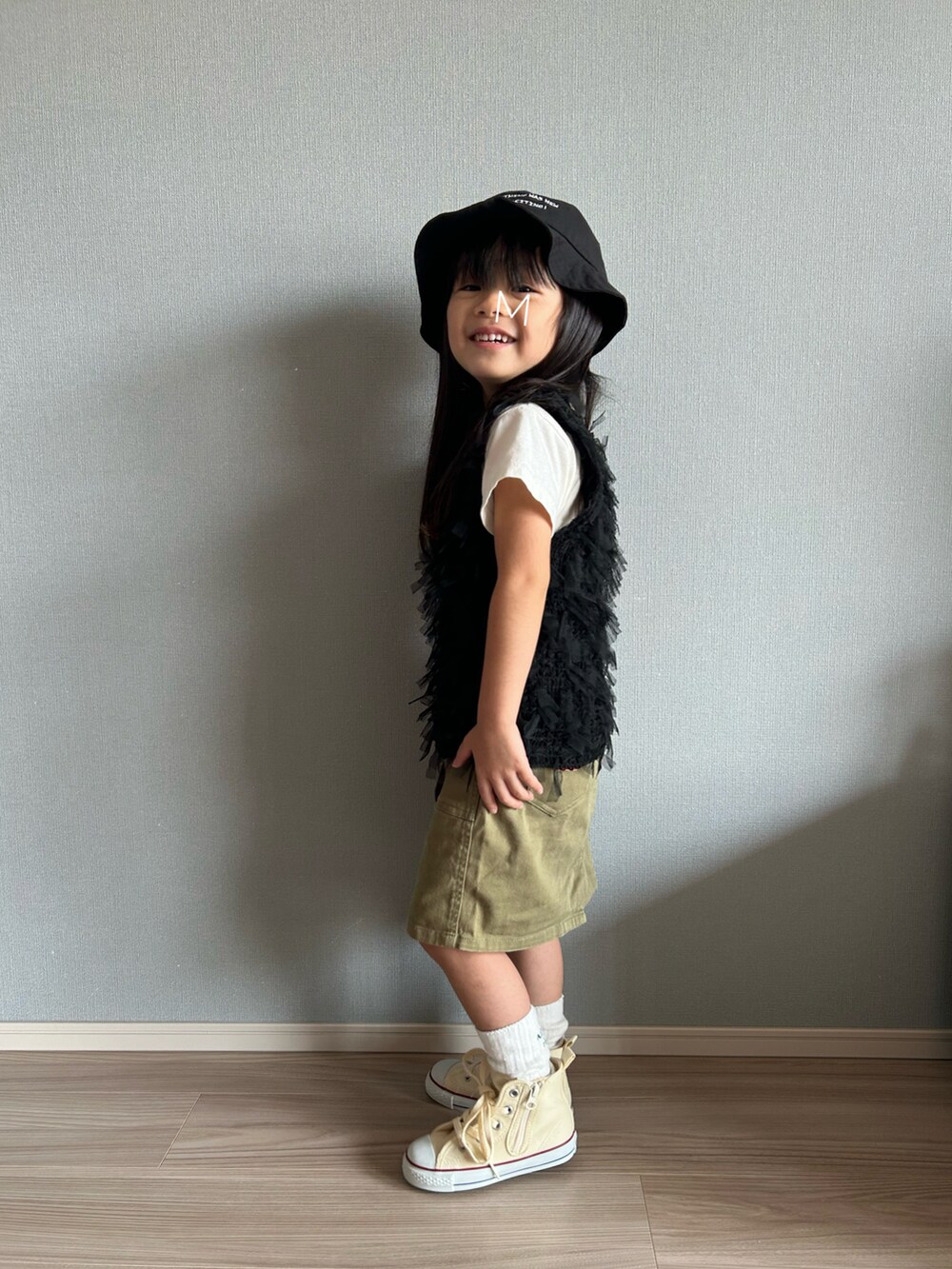 ホワイト系のTシャツ/カットソー、ブラック系のTシャツ/カットソー、グリーン系のスカートを着用したキッズの秋コーディネートの2枚目の写真