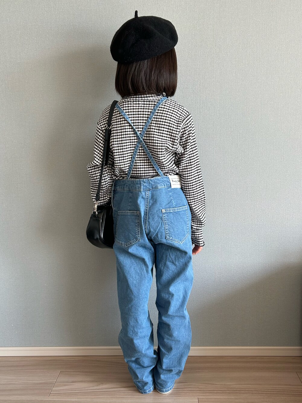 ブラック系のTシャツ/カットソー、ブルー系のサロペット/オーバーオール、ブラック系のスニーカーを着用したキッズの冬コーディネートの2枚目の写真