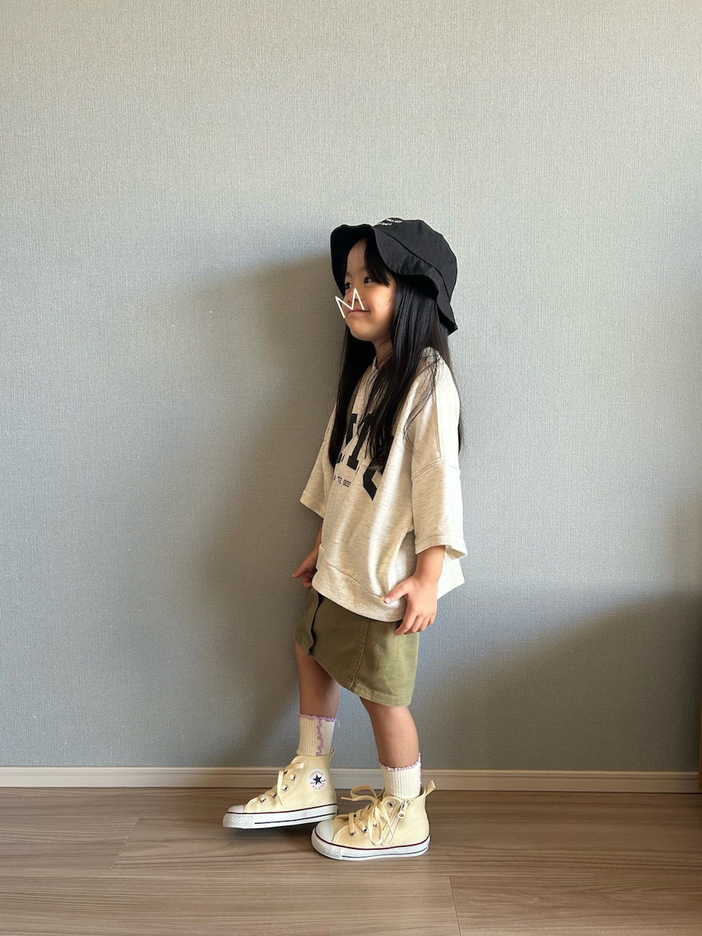 ホワイト系のTシャツ/カットソー、グリーン系のスカート、ホワイト系のスニーカーを着用したキッズの秋コーディネートの2枚目の写真