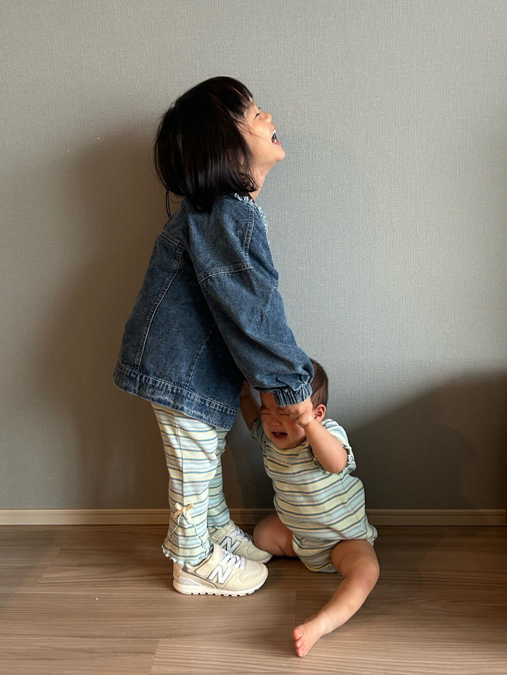 ブルー系のデニムジャケット、ブルー系のパンツ、ホワイト系のスニーカーを着用したキッズの秋コーディネートの2枚目の写真